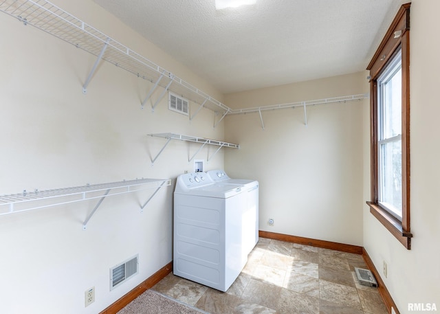 1010 S 6th St, Clinton, IA 52732 - washroom featuring independent washer and dryer, plenty of natural light, and stone finish flooring