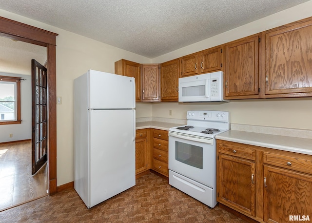 1010 S 6th St, Clinton, IA 52732 - kitchen with white appliances, brown cabinets, light countertops, and a textured ceiling