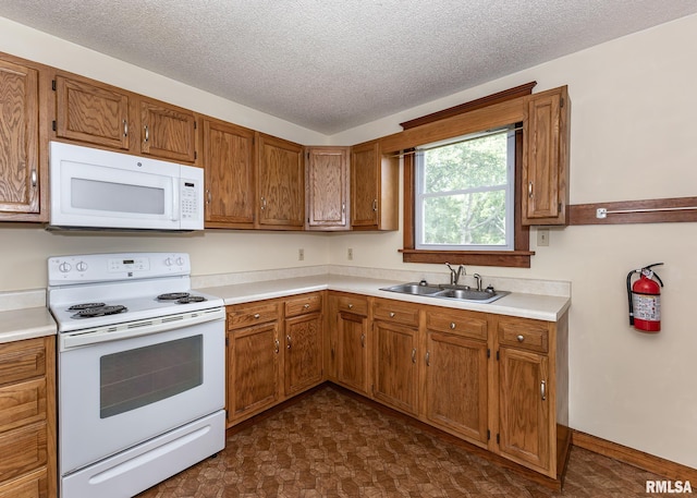 1010 S 6th St, Clinton, IA 52732 - kitchen featuring white appliances, light countertops, brown cabinets, and a textured ceiling