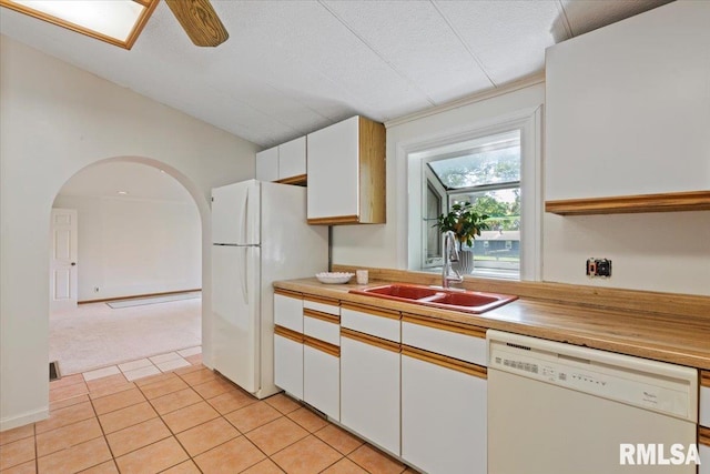 kitchen featuring white appliances, a sink, white cabinets, light tile patterned floors, and light countertops