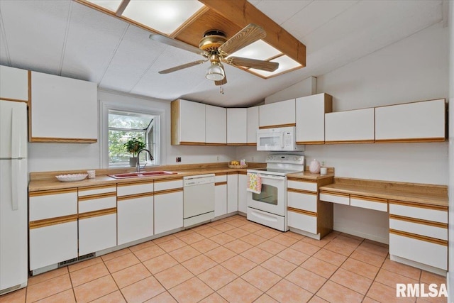 kitchen with white appliances, a sink, vaulted ceiling, and white cabinets