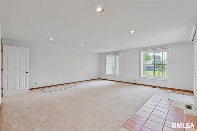 spare room with recessed lighting, light carpet, baseboards, and light tile patterned floors
