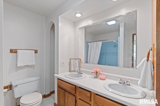 full bath with toilet, curtained shower, double vanity, and baseboards