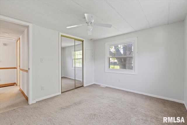 unfurnished bedroom with carpet floors, a closet, and baseboards