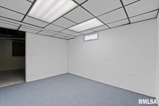 below grade area featuring a drop ceiling, carpet floors, and concrete block wall