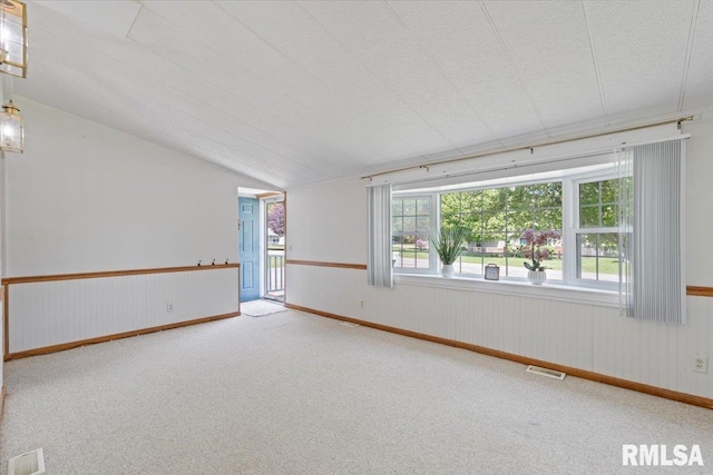 empty room with carpet flooring and lofted ceiling