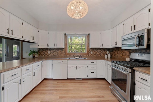 1401 265th St, Sherrard, IL 61281 - kitchen featuring stainless steel appliances, a sink, white cabinetry, and a chandelier