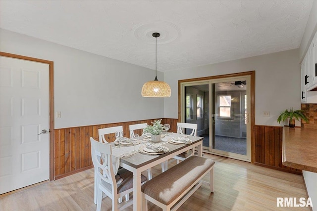 1401 265th St, Sherrard, IL 61281 - dining room with wainscoting, wooden walls, light wood-style flooring, and a textured ceiling