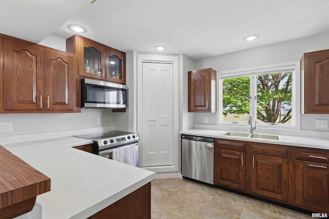 13218 300th St, Donahue, IA 52746 - kitchen with appliances with stainless steel finishes, a sink, light countertops, and glass insert cabinets