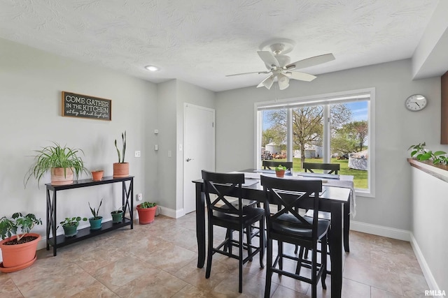 13218 300th St, Donahue, IA 52746 - dining area featuring a ceiling fan, baseboards, and a textured ceiling