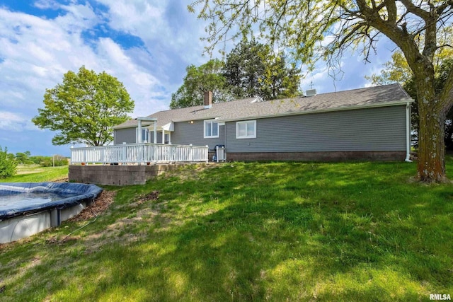 13218 300th St, Donahue, IA 52746 - rear view of property with a deck, a yard, a covered pool, and a chimney
