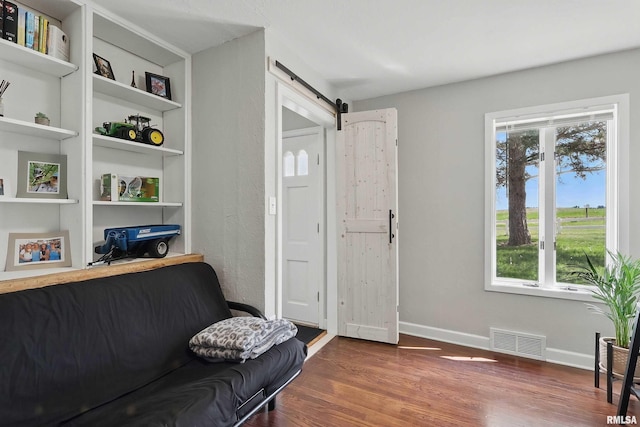 13218 300th St, Donahue, IA 52746 - sitting room featuring wood finished floors, a barn door, plenty of natural light, and baseboards