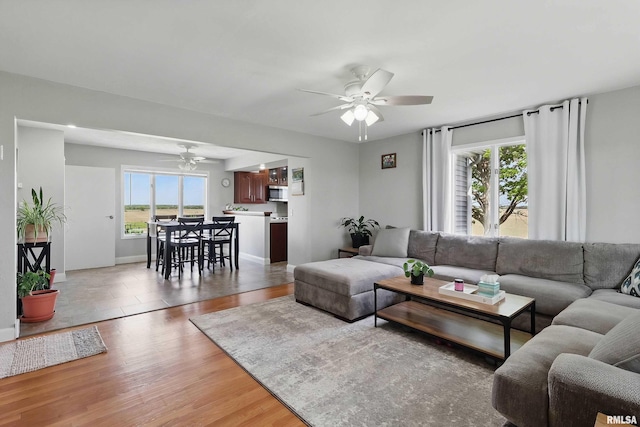 13218 300th St, Donahue, IA 52746 - living room featuring ceiling fan, light wood-style flooring, and baseboards