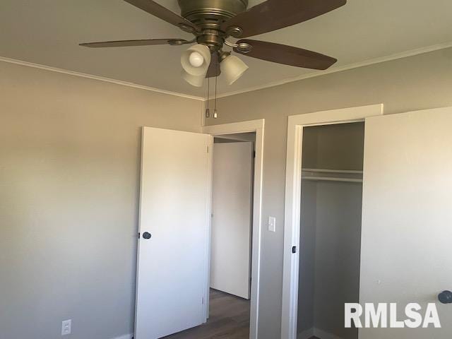 2712 30th St, Rock Island, IL 61201 - unfurnished bedroom with ornamental molding, a closet, dark wood-style flooring, and ceiling fan