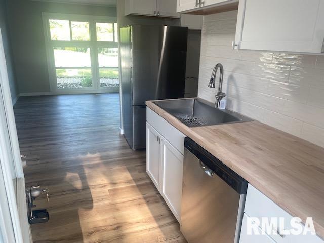2712 30th St, Rock Island, IL 61201 - kitchen with stainless steel appliances, a sink, light wood-style flooring, and white cabinetry