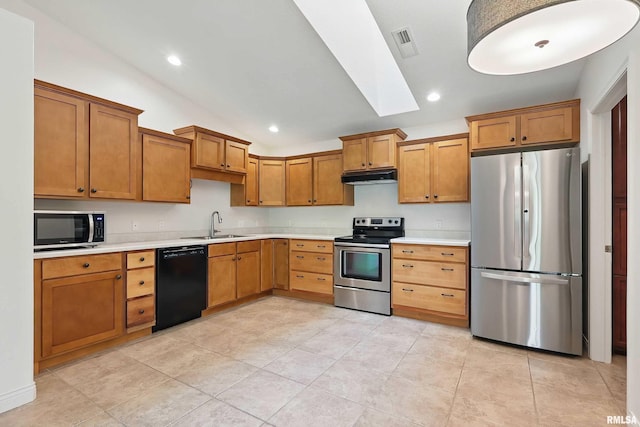 kitchen featuring stainless steel appliances, under cabinet range hood, light countertops, lofted ceiling, and a skylight