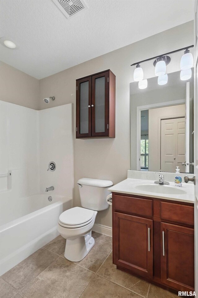 bathroom with toilet, vanity, baseboards, tile patterned floors, and shower / washtub combination