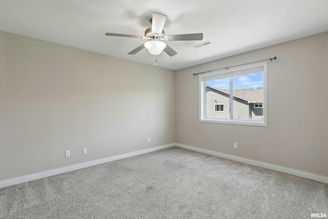 carpeted empty room featuring ceiling fan and baseboards