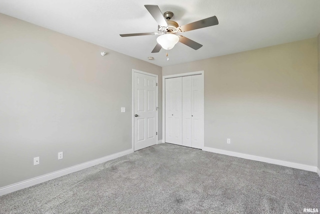 unfurnished bedroom with carpet flooring, baseboards, and a closet