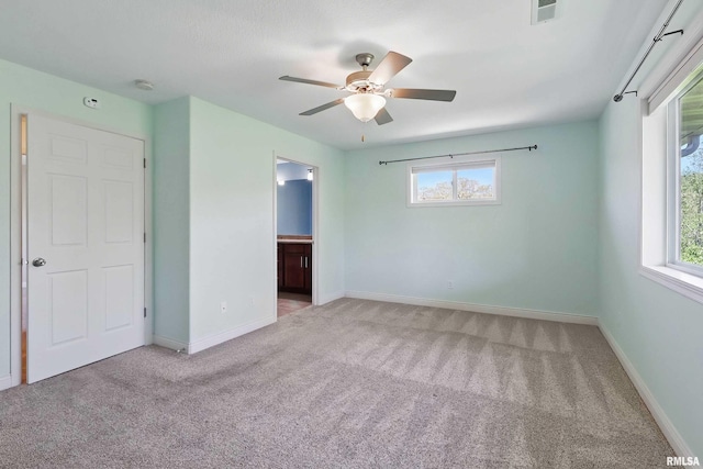 unfurnished bedroom with carpet, multiple windows, and baseboards