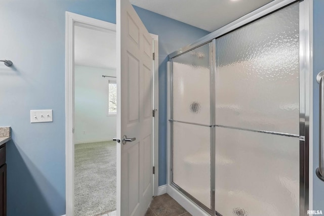 full bathroom featuring vanity, a stall shower, and baseboards