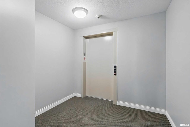 unfurnished room featuring dark colored carpet, a textured ceiling, baseboards, and a smoke detector