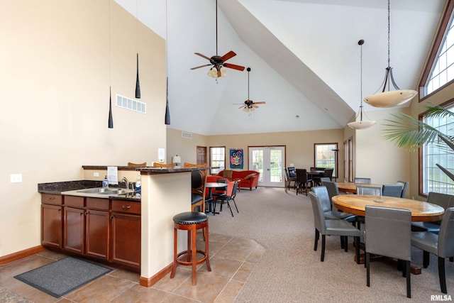 dining area featuring high vaulted ceiling, baseboards, ceiling fan, and light colored carpet