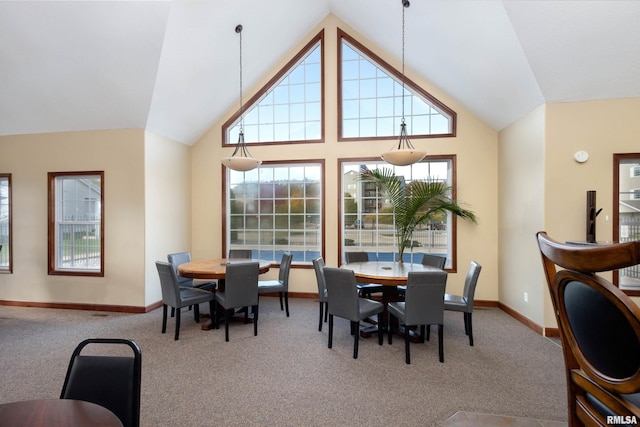 dining space featuring carpet, baseboards, and high vaulted ceiling