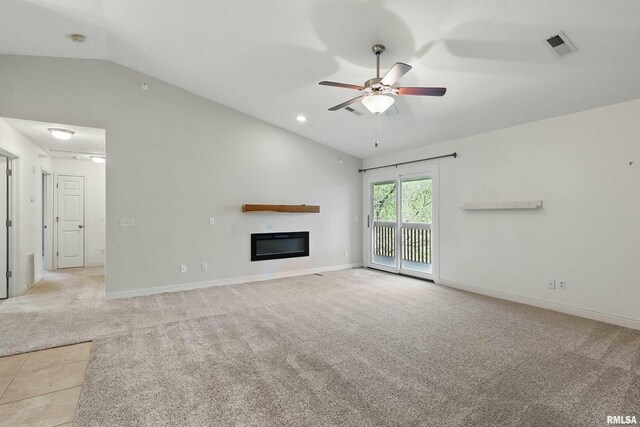 unfurnished living room with vaulted ceiling, ceiling fan, light colored carpet, a glass covered fireplace, and baseboards