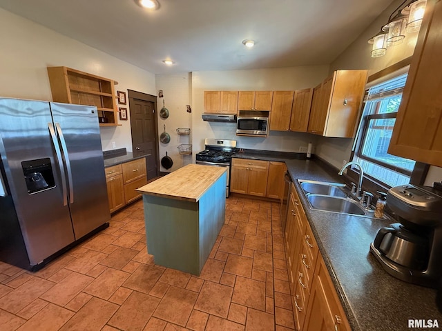 kitchen featuring appliances with stainless steel finishes, a sink, wood counters, under cabinet range hood, and a kitchen island