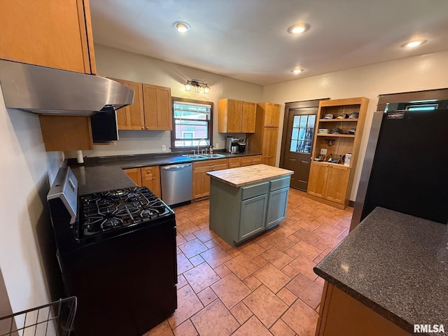 kitchen featuring stainless steel appliances, a sink, butcher block counters, under cabinet range hood, and a center island