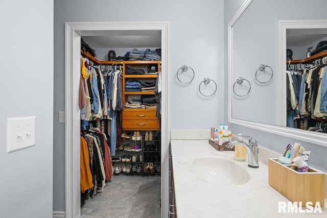 bathroom featuring vanity and a walk in closet