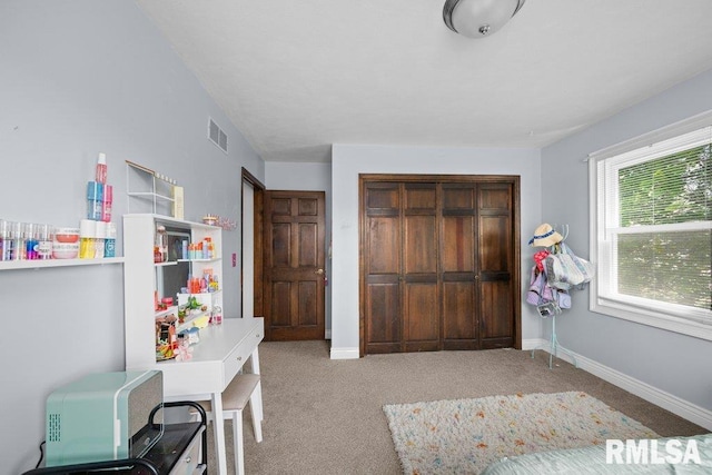carpeted bedroom featuring a closet and baseboards