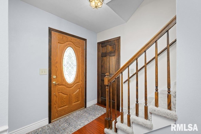 entryway featuring wood finished floors, stairs, and baseboards