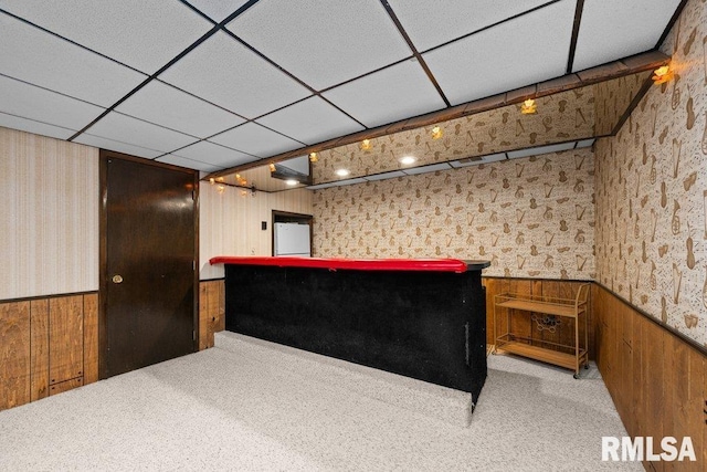 reception with wallpapered walls, wainscoting, a dry bar, and wood walls