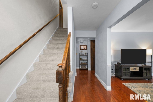stairs featuring wood finished floors and baseboards
