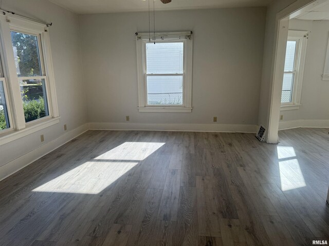 spare room featuring wood finished floors, baseboards, and ceiling fan