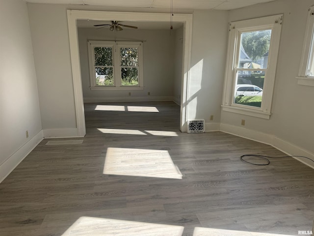 unfurnished dining area featuring a ceiling fan, baseboards, and wood finished floors