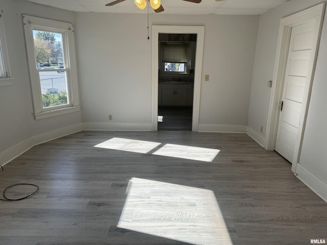 unfurnished bedroom featuring baseboards, wood finished floors, and a sink