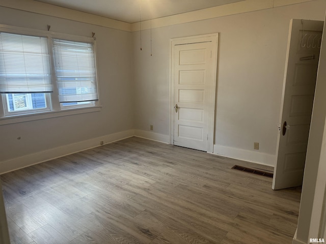 empty room with wood finished floors and baseboards