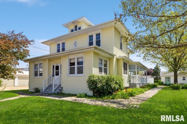 american foursquare style home with entry steps and a front lawn