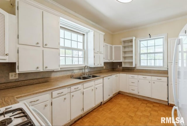 kitchen with a sink, white appliances, ornamental molding, white cabinets, and light countertops