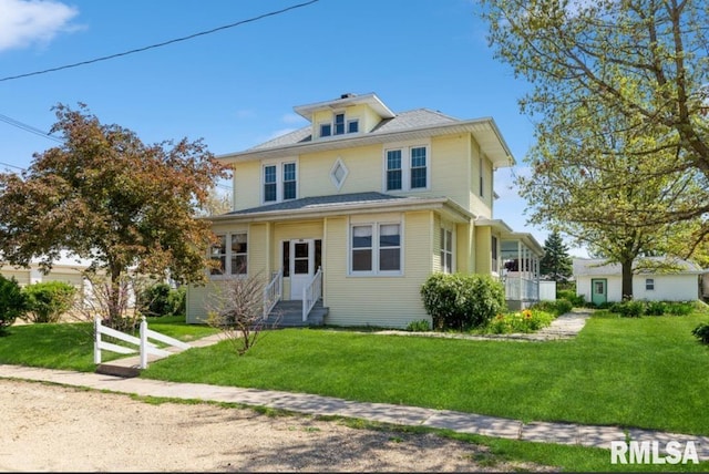 american foursquare style home featuring a front lawn and entry steps