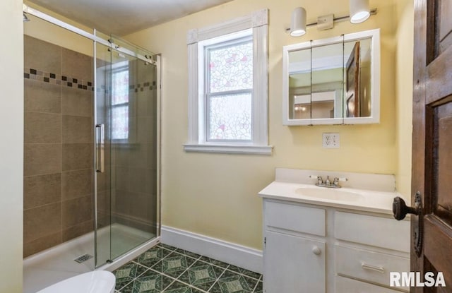 bathroom with a shower stall, tile patterned floors, vanity, and baseboards