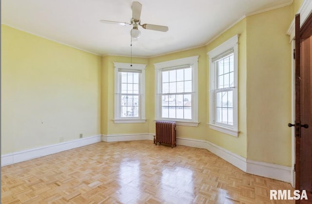empty room featuring radiator, a ceiling fan, baseboards, and ornamental molding