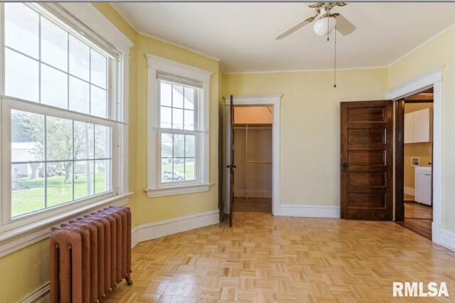 bedroom with radiator, multiple windows, baseboards, and ornamental molding
