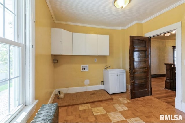 clothes washing area with cabinet space, washer hookup, crown molding, plenty of natural light, and baseboards