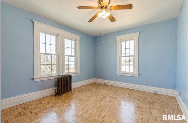 empty room featuring radiator, baseboards, and ceiling fan