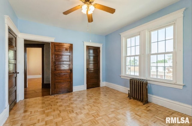 unfurnished bedroom with radiator, baseboards, and a ceiling fan
