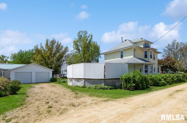 view of side of property featuring a garage and an outdoor structure